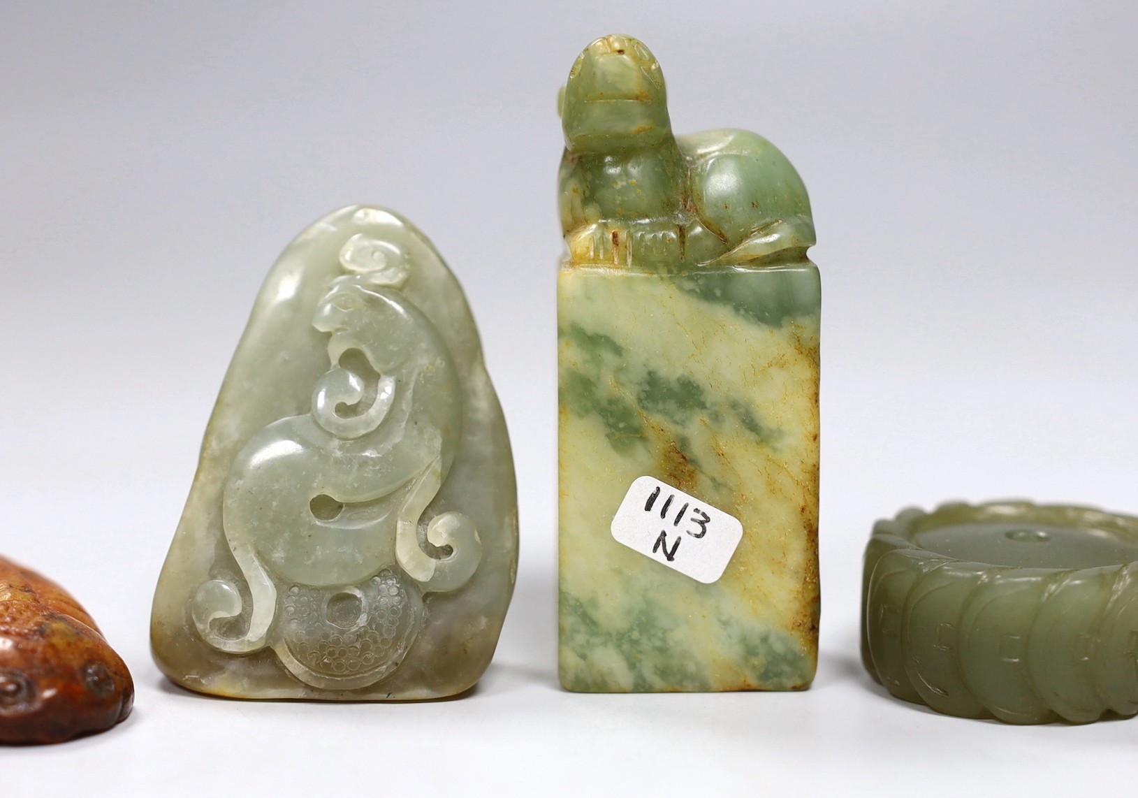 A Chinese green jade 'cash' wheel and a russet jade cicada, a jade pebble carving and a hardstone seal